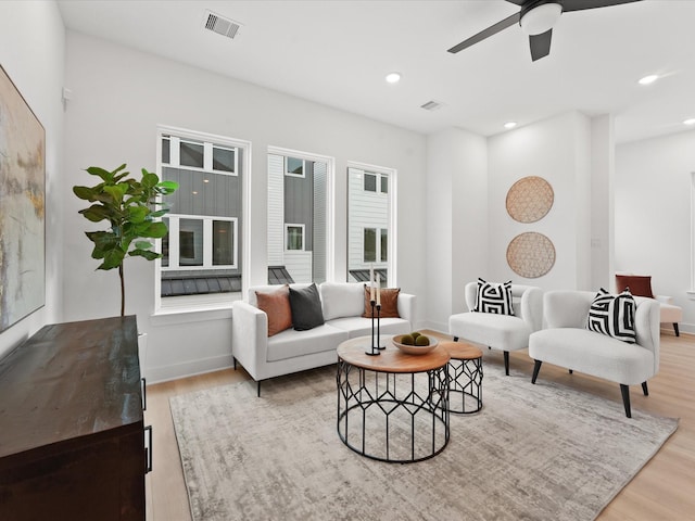 living room with light hardwood / wood-style flooring and ceiling fan