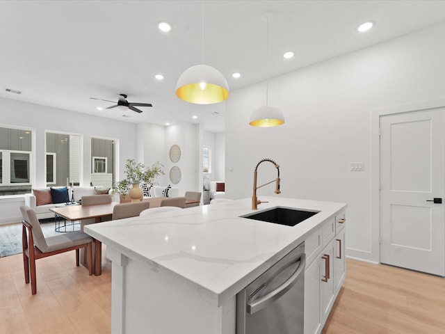 kitchen with sink, decorative light fixtures, a center island with sink, stainless steel dishwasher, and white cabinets