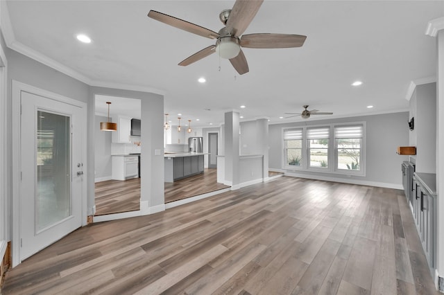 unfurnished living room featuring ornamental molding, light hardwood / wood-style floors, and ceiling fan