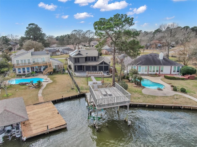 dock area featuring a patio area, a pool side deck with water view, and a lawn