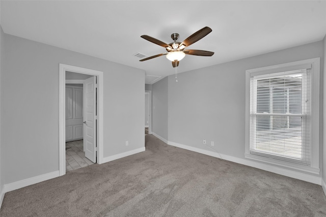 unfurnished bedroom featuring connected bathroom, light carpet, and ceiling fan