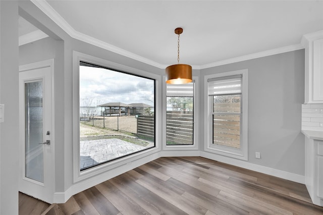 unfurnished dining area featuring crown molding and hardwood / wood-style floors