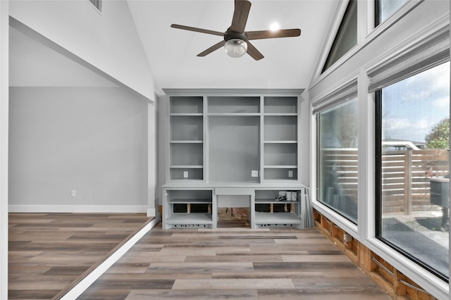 unfurnished living room with hardwood / wood-style flooring, lofted ceiling, and built in features