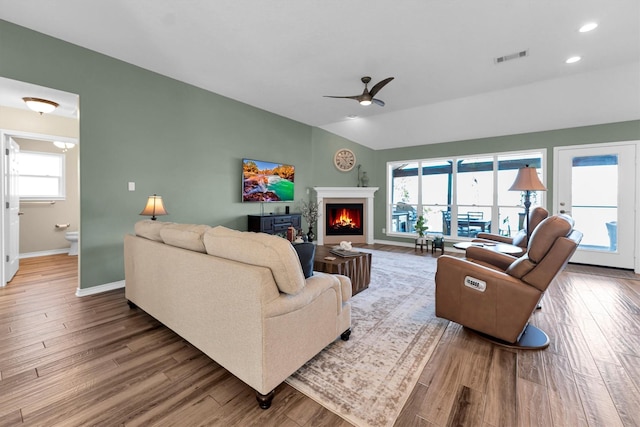 living room with lofted ceiling, hardwood / wood-style floors, and ceiling fan