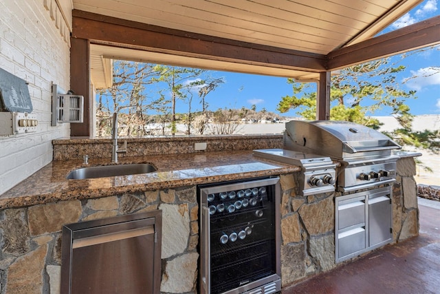 view of patio with area for grilling, sink, beverage cooler, and an outdoor kitchen