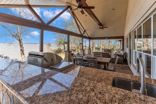 sunroom / solarium featuring sink, vaulted ceiling with beams, ceiling fan, wood ceiling, and a water view