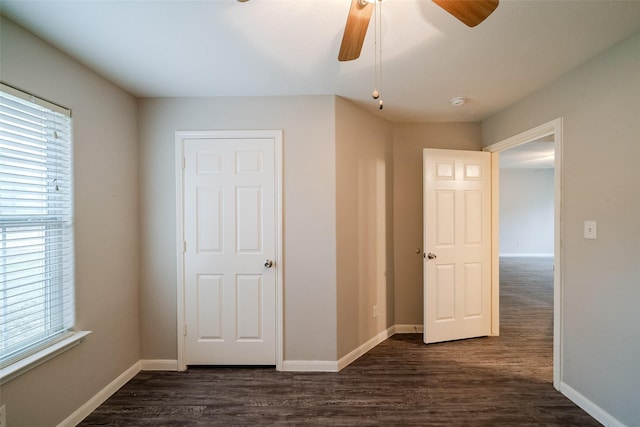 unfurnished bedroom featuring ceiling fan and dark hardwood / wood-style flooring