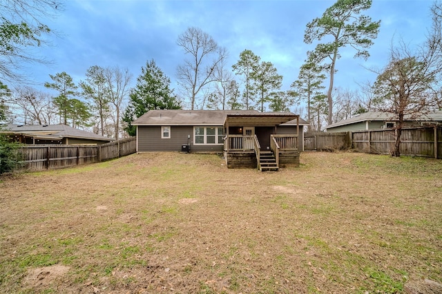 back of property with a wooden deck and a lawn