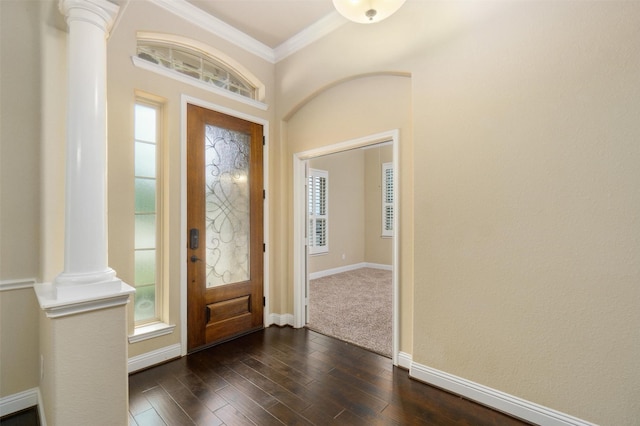 entrance foyer featuring dark wood-type flooring, ornamental molding, a wealth of natural light, and ornate columns