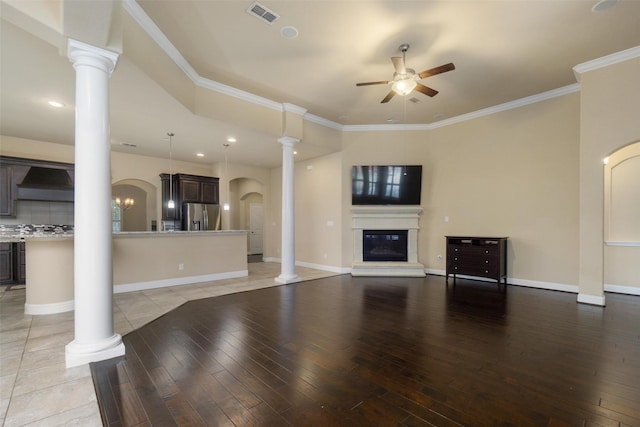 unfurnished living room featuring ceiling fan, ornamental molding, decorative columns, and light hardwood / wood-style flooring