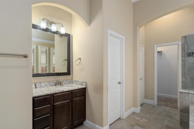 bathroom with an enclosed shower, vanity, and tile patterned floors