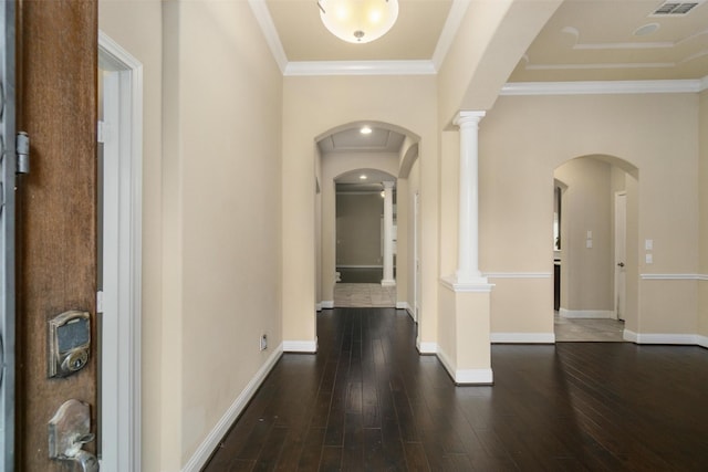 hallway featuring crown molding, dark wood-type flooring, and ornate columns