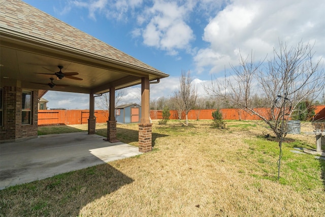 view of yard featuring a storage unit, ceiling fan, and a patio area