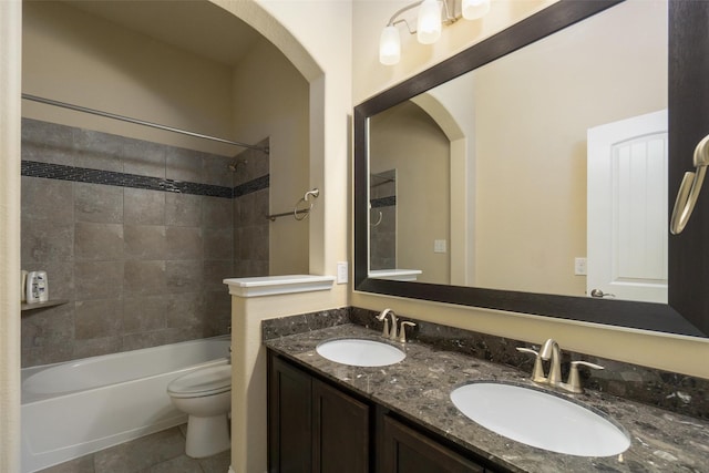 full bathroom featuring tiled shower / bath, vanity, tile patterned floors, and toilet