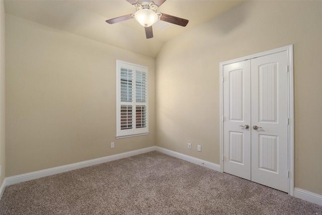 unfurnished bedroom featuring vaulted ceiling, a closet, ceiling fan, and carpet flooring