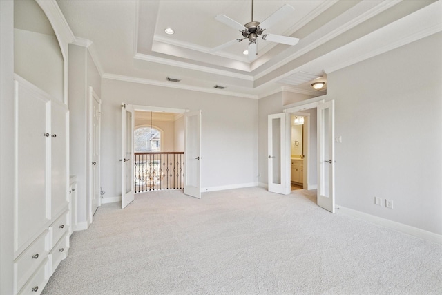 unfurnished bedroom featuring baseboards, ornamental molding, a raised ceiling, and light colored carpet