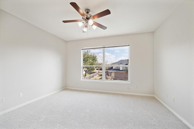 empty room with carpet floors, ceiling fan, and baseboards