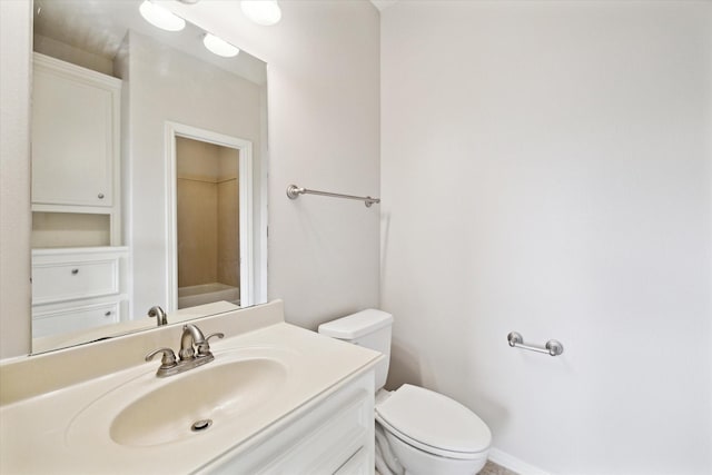 bathroom with toilet, baseboards, and vanity