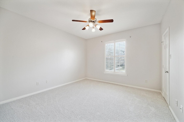 spare room featuring light carpet, ceiling fan, and baseboards