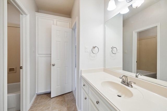 bathroom featuring a tub to relax in, vanity, and tile patterned floors