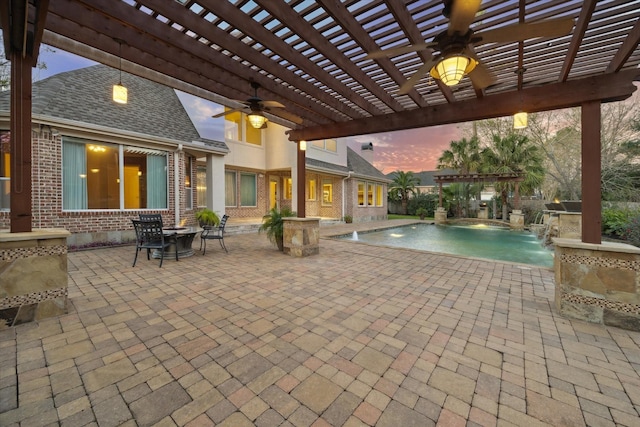 pool at dusk with pool water feature, a patio area, and a pergola