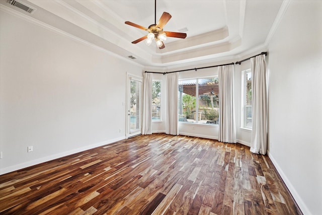 empty room with ornamental molding, hardwood / wood-style floors, ceiling fan, and a tray ceiling