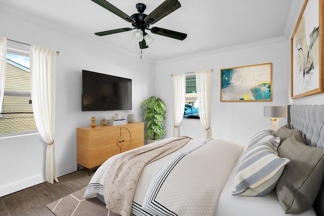 bedroom with ornamental molding, dark wood-type flooring, and ceiling fan