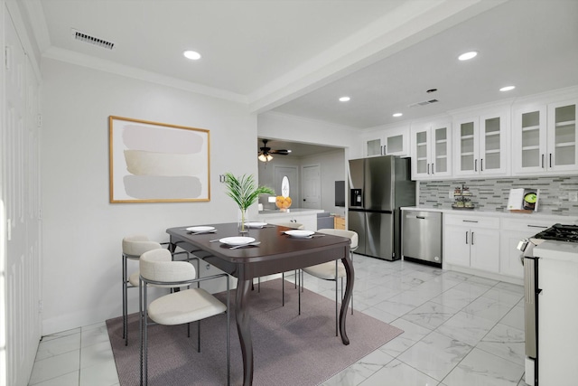 dining space with crown molding and ceiling fan