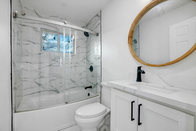 full bathroom featuring vanity, combined bath / shower with glass door, and toilet