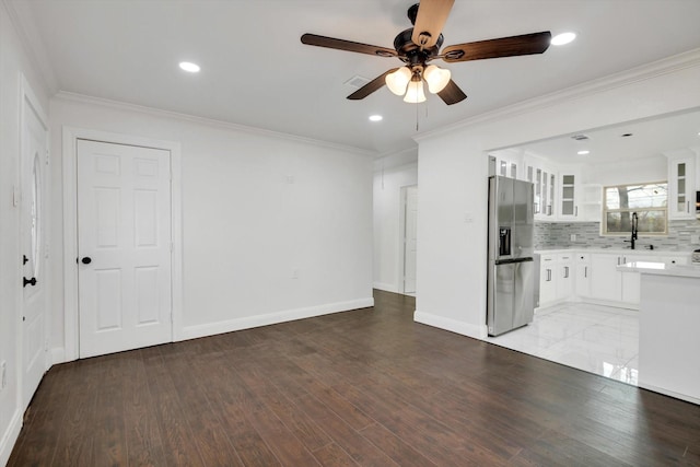 unfurnished living room featuring ornamental molding, wood-type flooring, and sink