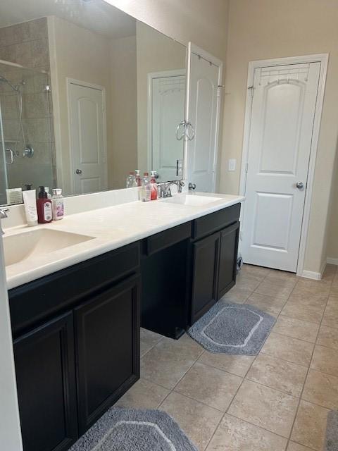 bathroom with tile patterned flooring, vanity, and an enclosed shower