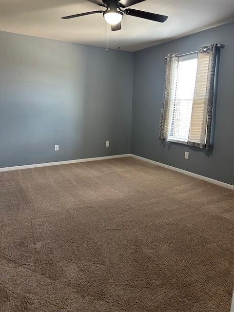 carpeted empty room featuring ceiling fan