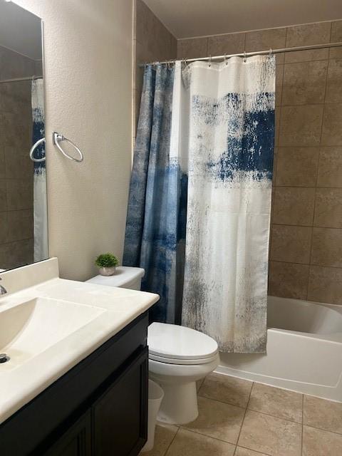 full bathroom with tile patterned flooring, vanity, shower / tub combo, and toilet