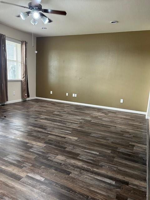 empty room featuring ceiling fan and dark hardwood / wood-style flooring