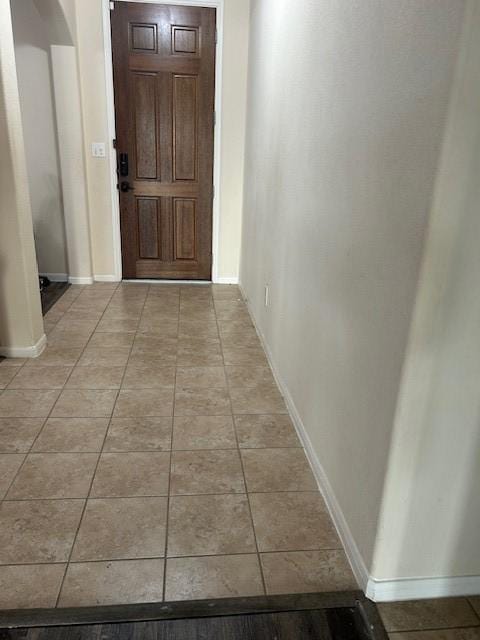 hall with light tile patterned floors