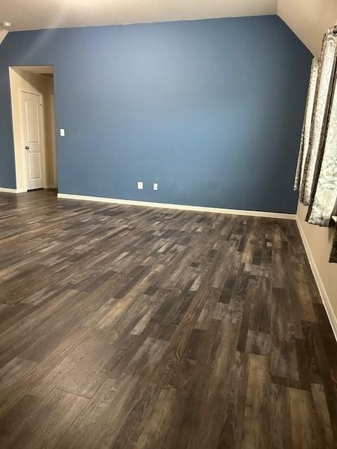 interior space with vaulted ceiling and dark hardwood / wood-style flooring