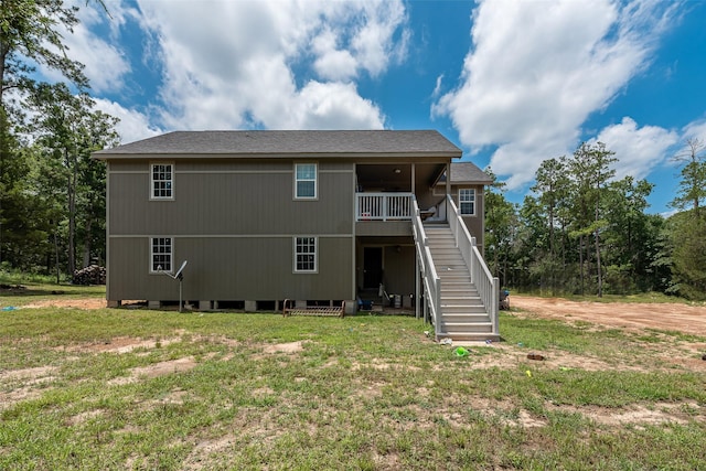 rear view of property featuring a lawn