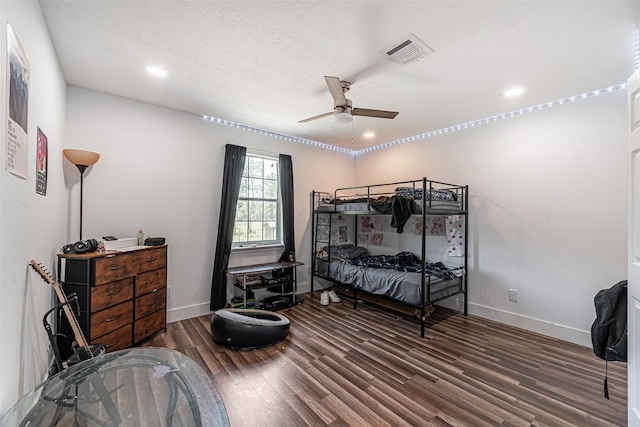 bedroom with ceiling fan, dark wood-type flooring, and a textured ceiling