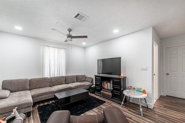 living room featuring ceiling fan, wood-type flooring, and a textured ceiling