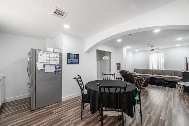 dining room featuring ceiling fan, dark wood-type flooring, and a textured ceiling