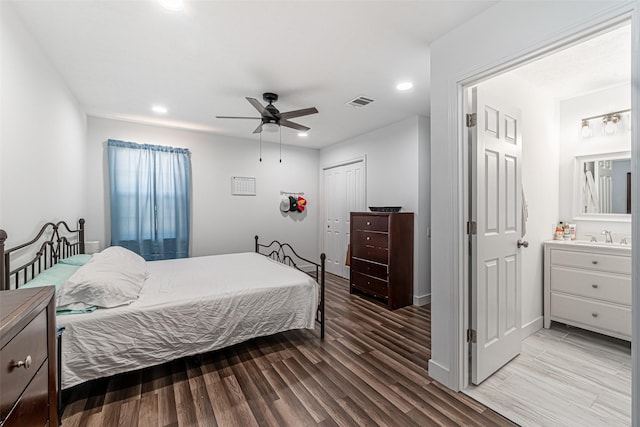 bedroom with ceiling fan, sink, light hardwood / wood-style floors, and a closet