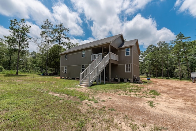 rear view of house featuring a yard