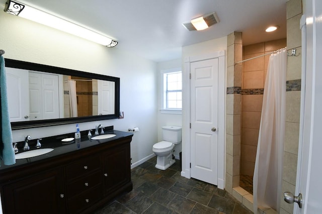 bathroom with vanity, curtained shower, and toilet