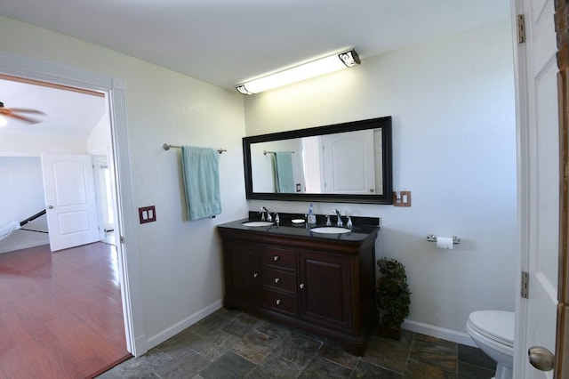 bathroom with ceiling fan, vanity, and toilet