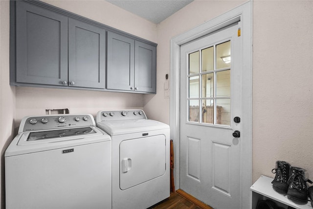 clothes washing area with cabinets, washer and dryer, and dark hardwood / wood-style floors