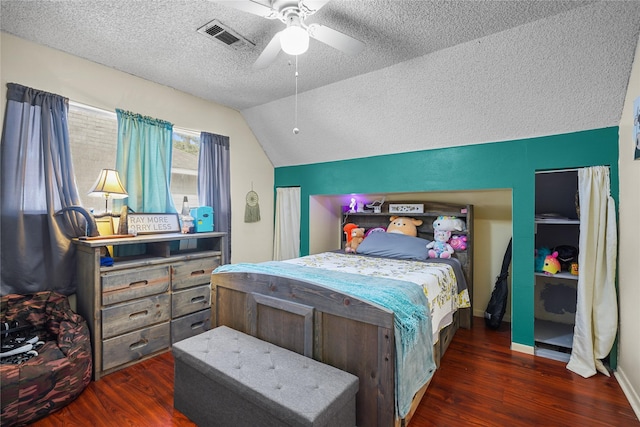 bedroom with ceiling fan, lofted ceiling, dark hardwood / wood-style floors, and a textured ceiling