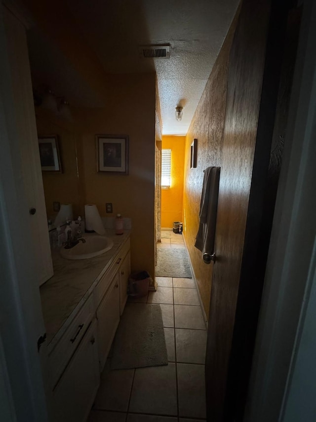 bathroom featuring tile patterned flooring, vanity, and a textured ceiling