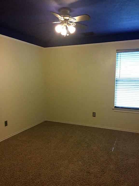 carpeted empty room featuring ceiling fan