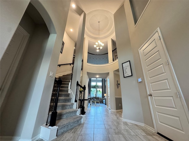 entryway featuring a towering ceiling and an inviting chandelier