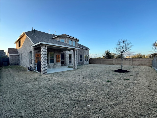 rear view of property featuring a yard and a patio area